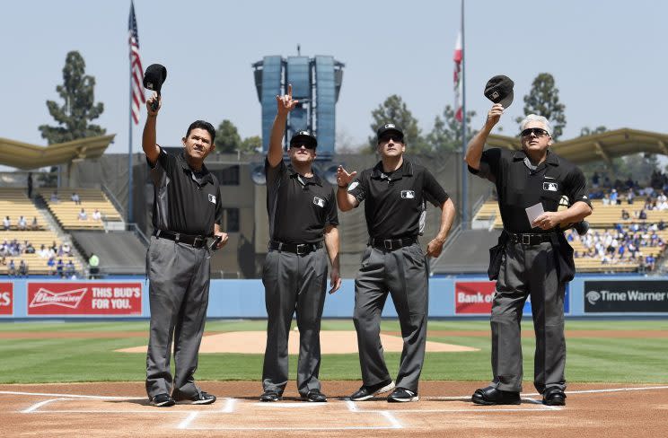 Umpires acknowledge Vin Scully prior to a game on Aug. 27. (AP)