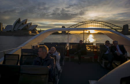 Commuters ride on the rooftop deck of a Sydney ferry at sunset en route to Rose Bay in Sydney's eastern suburbs, July 14, 2015. Picture taken July 14, 2015. REUTERS/Jason Reed