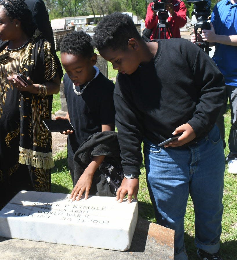 Brothers Connor Cheney, 11, and Gary Cheney, Jr., 9, were both moved to touch the marble headstone that was finally placed on the grave of their great-great uncle, World War II veteran Jasper Pers Kimble. The headstone sat neglected, covered with grass, weeds and paint splatter, for 15 years outside of a closed Alexandria funeral home.