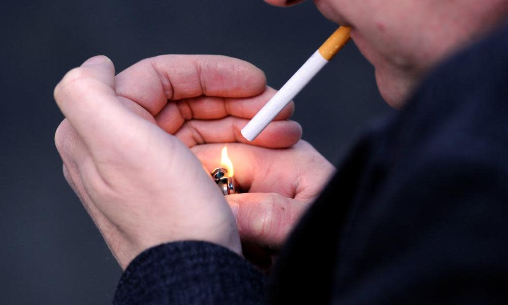 A man lighting a cigarette