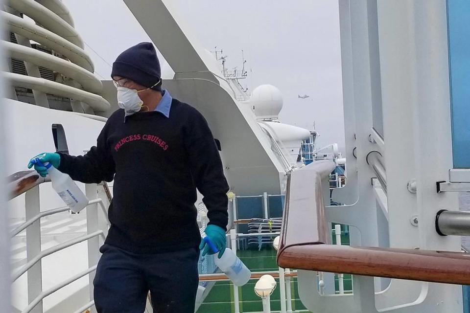 A cruise ship worker cleans a railing on the Grand Princess Thursday, March 5, 2020, off the California coast. Scrambling to keep the coronavirus at bay, officials ordered a cruise ship with about 3,500 people aboard to stay back from the California coast Thursday until passengers and crew can be tested, after a traveler from its previous voyage died of the disease and at least two others became infected.