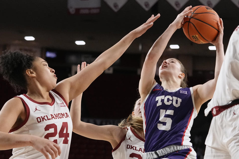 TCU guard Emily Fisher (5) shoots as Oklahoma guard Skylar Vann (24) defends in the first half of an NCAA college basketball game Tuesday, Jan. 31, 2023, in Norman, Okla. (AP Photo/Sue Ogrocki)