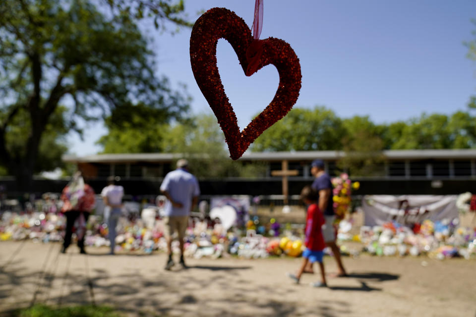 Mourners visit a make-shift memorial honoring the school shooting victims at Robb Elementary, Monday, July 11, 2022, in Uvalde, Texas. Students who survived the May 24 shooting at an elementary school in Uvalde, Texas are spending the summer grappling with post-traumatic stress disorder. Meanwhile, parents find themselves unable to help them, worried the tragedy at Robb Elementary struck a largely Hispanic town as Latinos continue to face disparities to access mental health care. (AP Photo/Eric Gay)