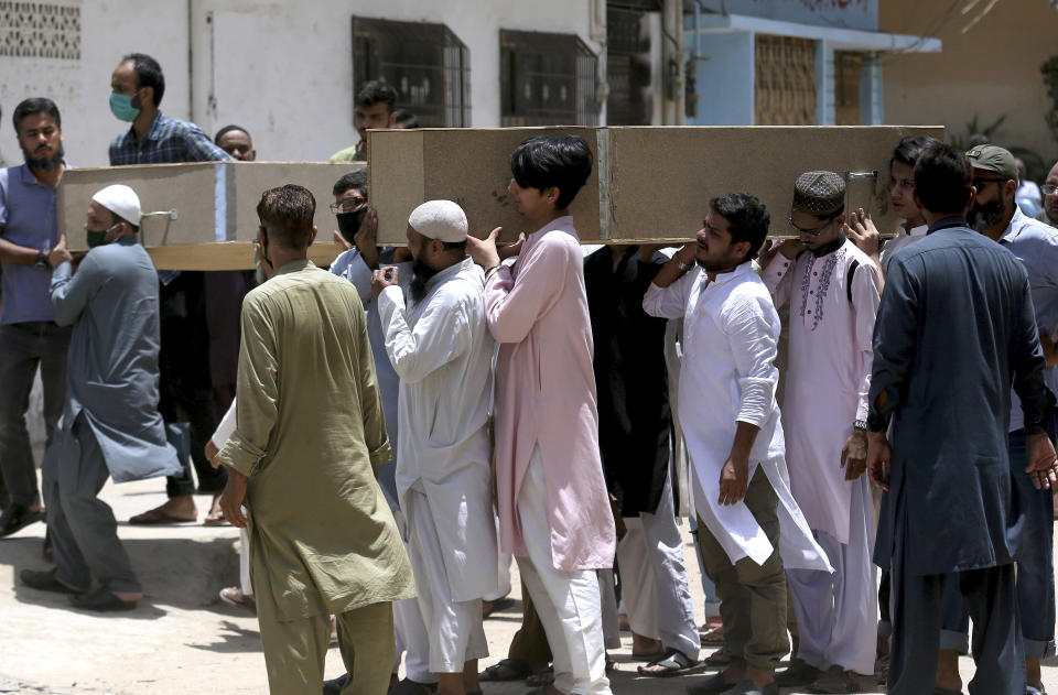 People carry the casket of the victims of Friday's plane crash for funeral prayers in Karachi, Pakistan, Saturday, May 23, 2020. An aviation official says a passenger plane belonging to state-run Pakistan International Airlines carrying passengers and crew has crashed near the southern port city of Karachi. (AP Photo/Fareed Khan)