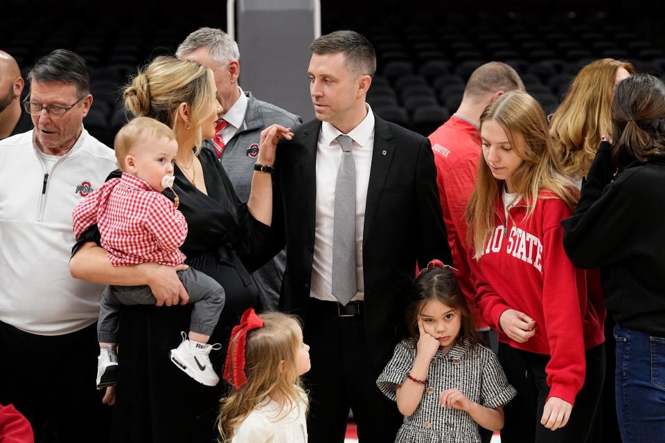 Mar 18, 2024; Columbus, OH, USA; Ohio State basketball head coach Jake Diebler talks to his wife, Jordyn, as he prepares to take a family photo during his introductory press conference at Value City Arena.