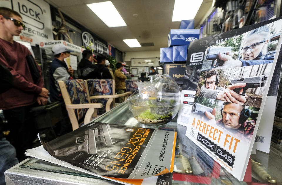 FILE - People wait in a line at a gun at store amid merchandise displays, in Arcadia, Calif., Sunday, March 15, 2020. Two California counties violated the Constitution's right to keep and bear arms when they shut down gun and ammunition stores in 2020 as nonessential businesses during the coronavirus pandemic, a federal appeals court ruled Thursday, Jan. 20, 2022.(AP Photo/Ringo H.W. Chiu,File)