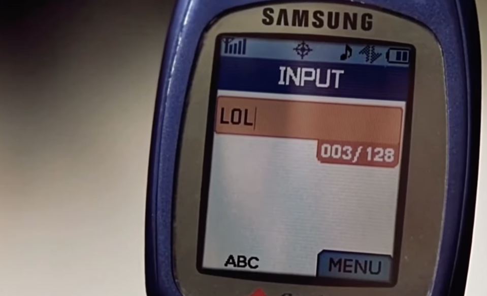 Old Samsung flip phone screen displaying text message inbox with "LOL" as the content of a message