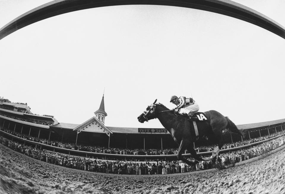 A fish-eye lens view of Secretariat, ridden by Ron Turcotte, thundering past the packed clubhouse at Churchill Downs.