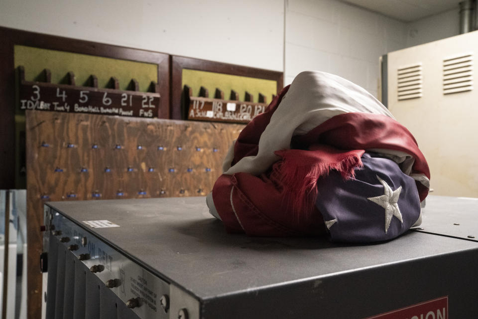 A balled--up American flag rests on a security X-ray machine in a decommissioned guard tower and visitor entrance at the former Arthur Kill Correctional Facility, Tuesday, May 11, 2021, in the Staten Island borough of New York. The facility was purchased by Broadway Stages in 2017 and has been transformed into a film and television studio. Much of the prison was preserved as a set, lending authenticity to scenes in productions. Five other sound stages are being built on the 69-acre site, giving production companies the ability to shoot entire projects. (AP Photo/John Minchillo)