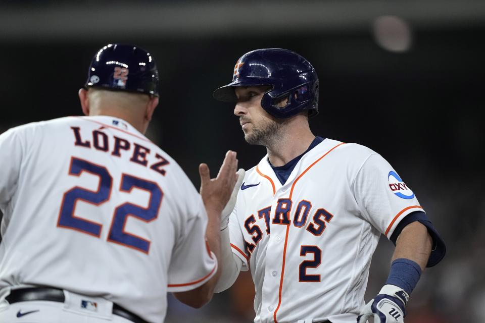 Houston Astros' Alex Bregman (2) celebrates with first base coach Omar López (22) after hitting a two-run single against the Los Angeles Angels during the fifth inning of a baseball game Thursday, June 1, 2023, in Houston. (AP Photo/David J. Phillip)