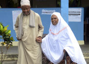 A local helps an old woman to the polling station to cast her vote in Zanzibar, Tanzania, Wednesday. Oct.28, 2020. Tanzania's other top opposition party, ACT Wazalendo, accused police of shooting dead nine people in the semi-autonomous region of Zanzibar. (AP Photo)