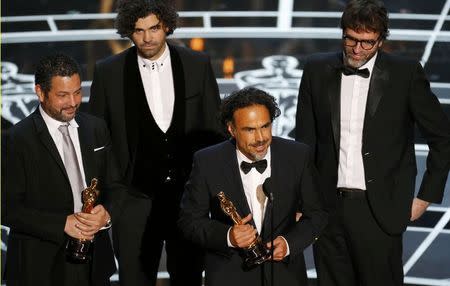 Alejandro G. Inarritu (2nd R) speaks along with writers Alexander Dinelaris, Armando Bo, and Nicolas Giacobone (L-R), winners for best original screenplay for the film "Birdman," at the 87th Academy Awards in Hollywood, California February 22, 2015. REUTERS/Mike Blake