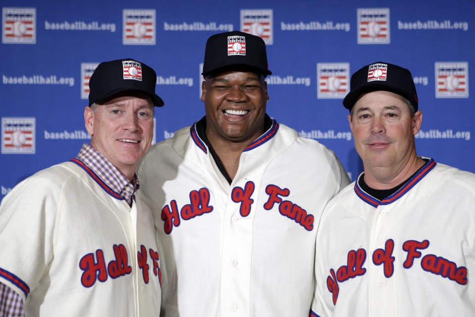 FILE - In this Jan. 9, 2014, file photo, former Atlanta Braves pitchers Tom Glavine, left and Greg Maddux, right, pose with Chicago White Sox slugger Frank Thomas after a press conference in New York, announcing their election to the Baseball Hall of Fame. Maddux will not have any logo on his cap in his Hall of Fame plaque, the Hall said Thursday, Jan. 23, 2014. Glavine's will have a Braves logo, while Thomas' will have a White Sox logo. (AP Photo/Kathy Willens, File)