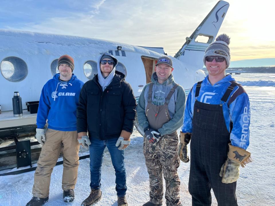 From left to right, Derek Davis, Jonah Alain, Jordan Janzen and Lee Saretsky pose in front of their ice fishing shack aircraft.