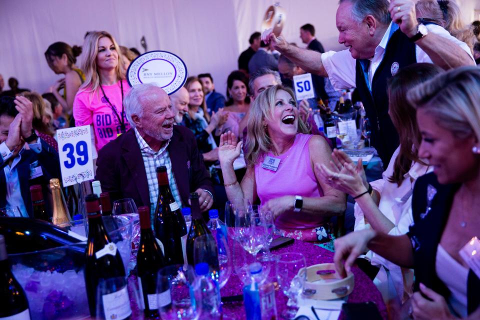 Scott and Simone Lutgert celebrate winning lot 5, "Love is Bleu," during the Naples Winter Wine Festival live auction at The Ritz-Carlton Golf Resort in Naples on Saturday, January 25, 2020.