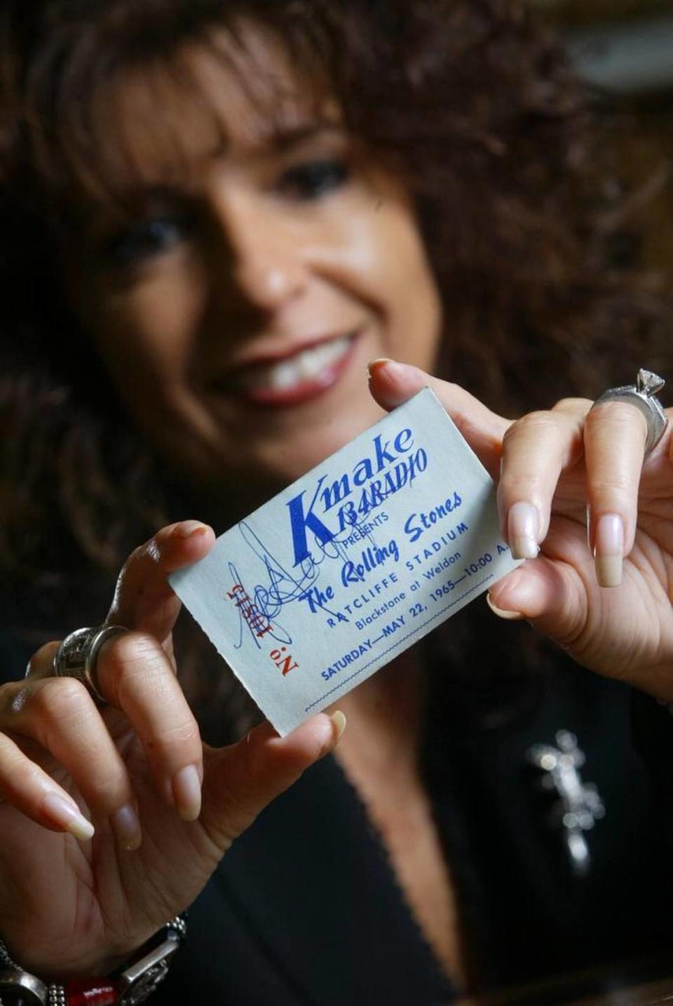 FRESNO, CA. 11/10/05 LIF EPZ STONES ARMEN TICKET Armen Bacon holds the ticket she saved when she saw The Rolling Stones at Ratcliffe Stadium at the age of 13 in 1965. Bacon said she handed the ticket stub to an events worker and urged him to get a signature. The ticket stub now displays a signature which appears to say Mick Jagger although she never saw the ticket actually being signed. Photographed on Thursday, Dec. 10, 2005 in Fresno, CA. ERIC PAUL ZAMORA/THE FRESNO BEE