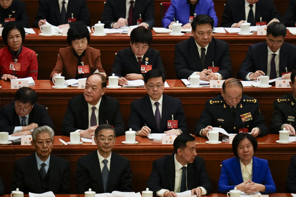 Hong Kong Chief Executive John Lee, center, attends the opening session of the National People's Congress (NPC) at the Great Hall of the People in Beijing, China, Tuesday, March 5, 2024. (AP Photo/Ng Han Guan)