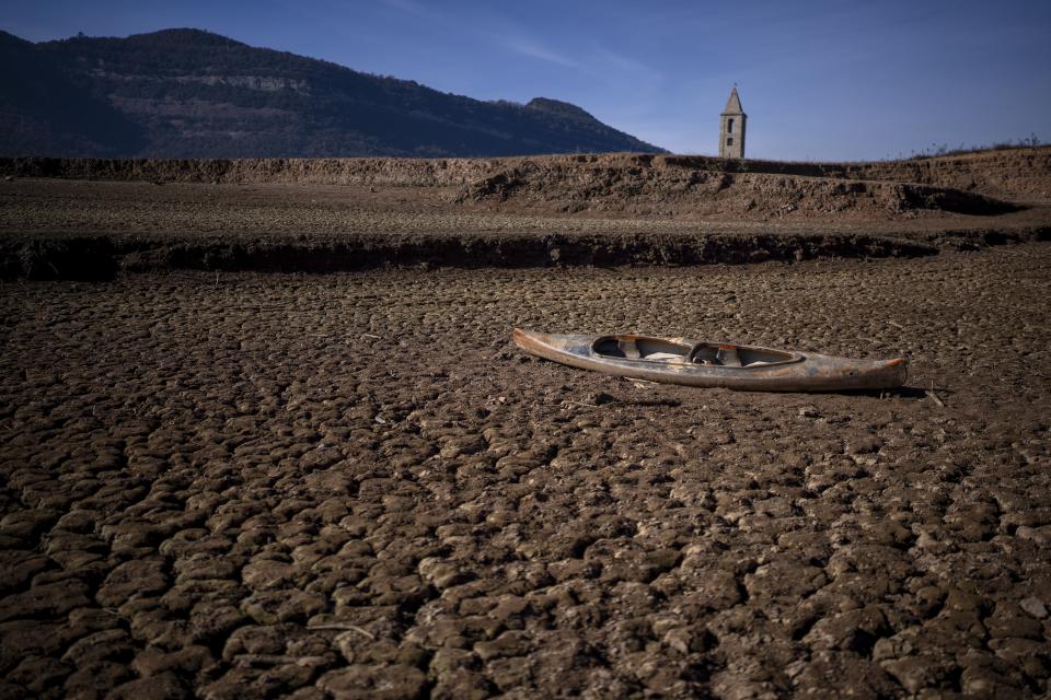 FILE - An abandoned canoe sits on the cracked ground amid a drought at the Sau reservoir, north of Barcelona, Spain, Monday, Jan. 22, 2024. Europe is facing growing climate risks and is unprepared for them, the European Environment Agency said in its first-ever risk assessment for the bloc Monday, March 11, 2024. (AP Photo/Emilio Morenatti, File)