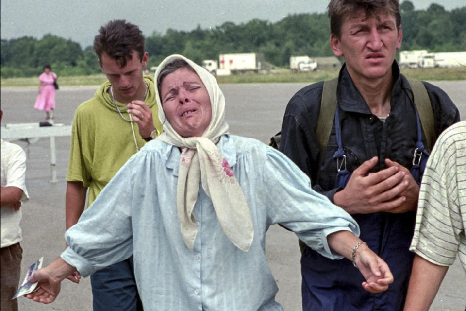 FILE- In this July 17, 1995, file picture, a Bosnian woman reacts after learning from Muslim men who arrived in Tuzla that her husband has been killed by Bosnian Serbs who overran the UN declared safe haven of Srebrenica. Survivors of the genocide in the eastern Bosnian town of Srebrenica, mainly women, will on Saturday July 11, 2020, commemorate the 25th anniversary of the slaughter of their fathers and brothers, husbands and sons. At least 8,000 mostly Muslim men and boys were chased through woods in and around Srebrenica by Serb troops in what is considered the worst carnage of civilians in Europe since World War II. The slaughter was also the only atrocity of the brutal war that has been confirmed an act of genocide.(AP Photo/Michel Euler, File)