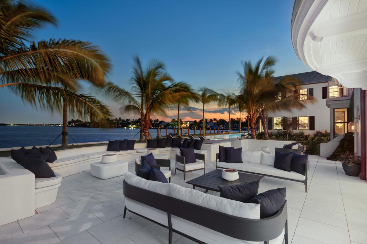 A waterfront patio at 10 Tarpon Island offers a view of the setting sun over the Intracoastal Waterway in Palm Beach.
