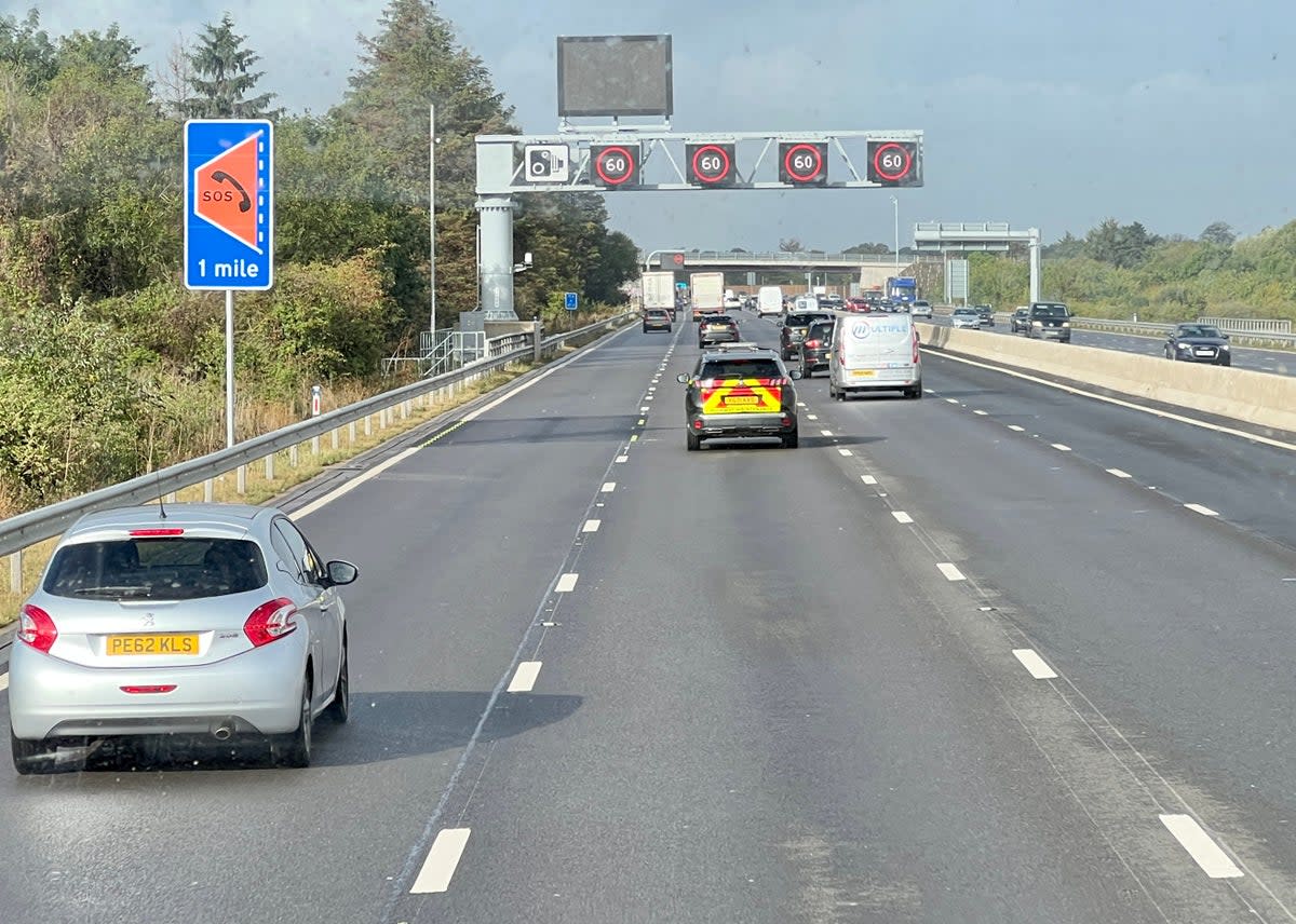 All-lane running: a ‘smart’ section of the M4 motorway west from London, showing a sign for an emergency refuge and gantry with speed restrictions (Simon Calder)