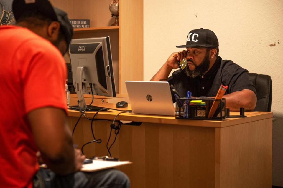 Ronald Clark, left, fills out a job placement form while Andre Harris talks on the phone about a felony expungement at Dads Against Crime in Kansas City. Zachary Linhares/The Kansas City Star