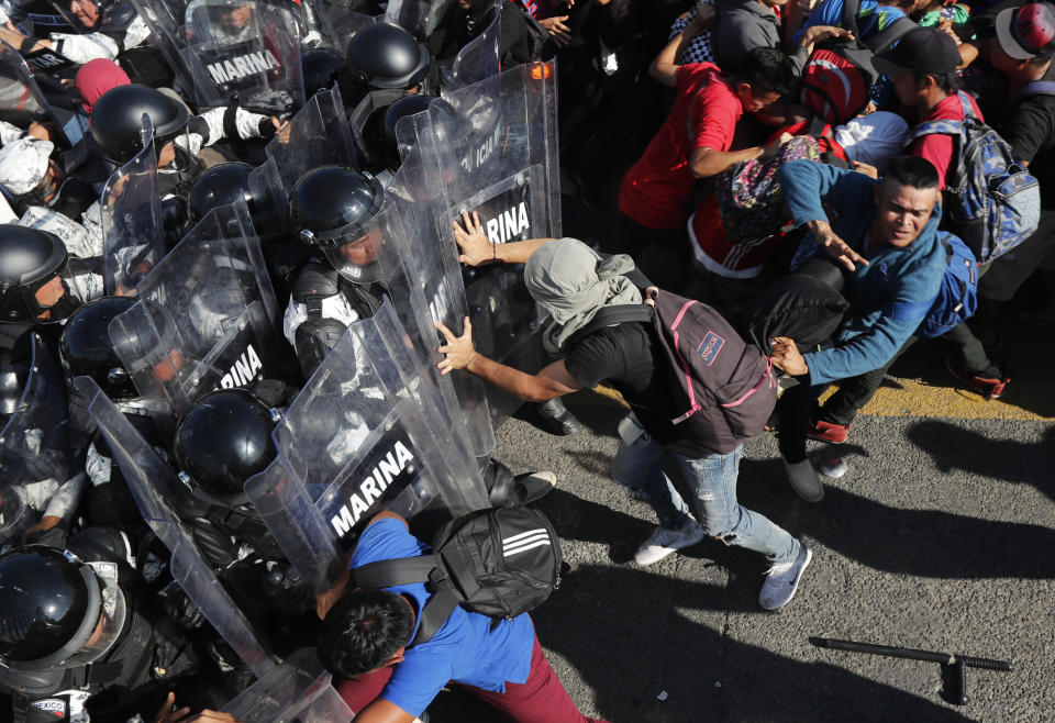 Fotografía del 18 de enero de 2020 de migrantes efrentándose a efectivos de la Guardia Nacional de México en el paso fronterizo con Guatemala cerca de Ciudad Hidalgo (México) y Tecún Umán (Guatemala). (AP Foto/Marco Ugarte)