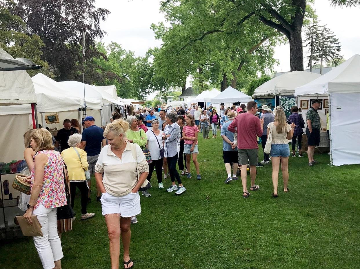 People walk through booths set up in Pennsylvania Park on Saturday, July 15, 2023 during Petoskey's Art in the Park.