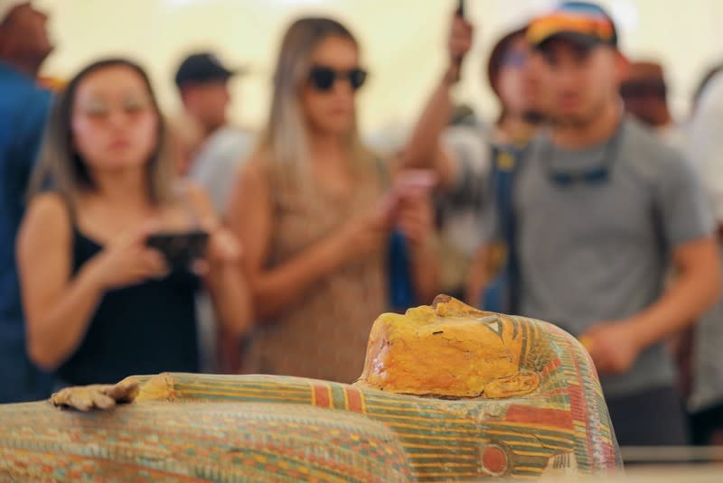 Tourists look at painted ancient coffins at Al-Asasif necropolis, unveiled by Egyptian antiquities officials in the Valley of the Kings in Luxor