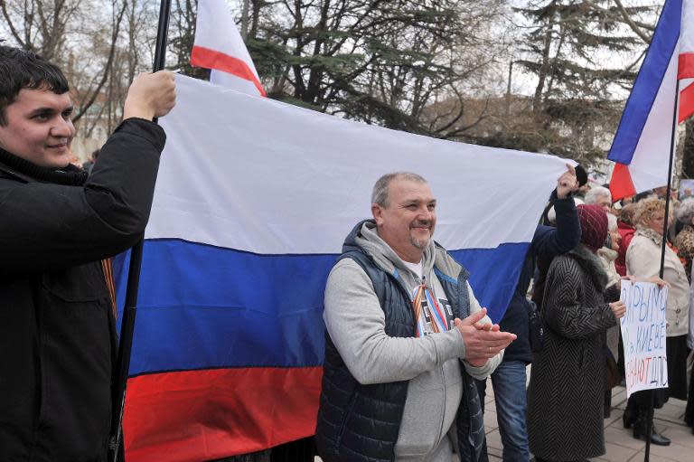 Pro-Russian activists hold a Russian flag during a rally in Simferopol on March 6, 2014