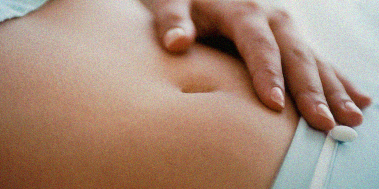 woman rests her hand on her stomach