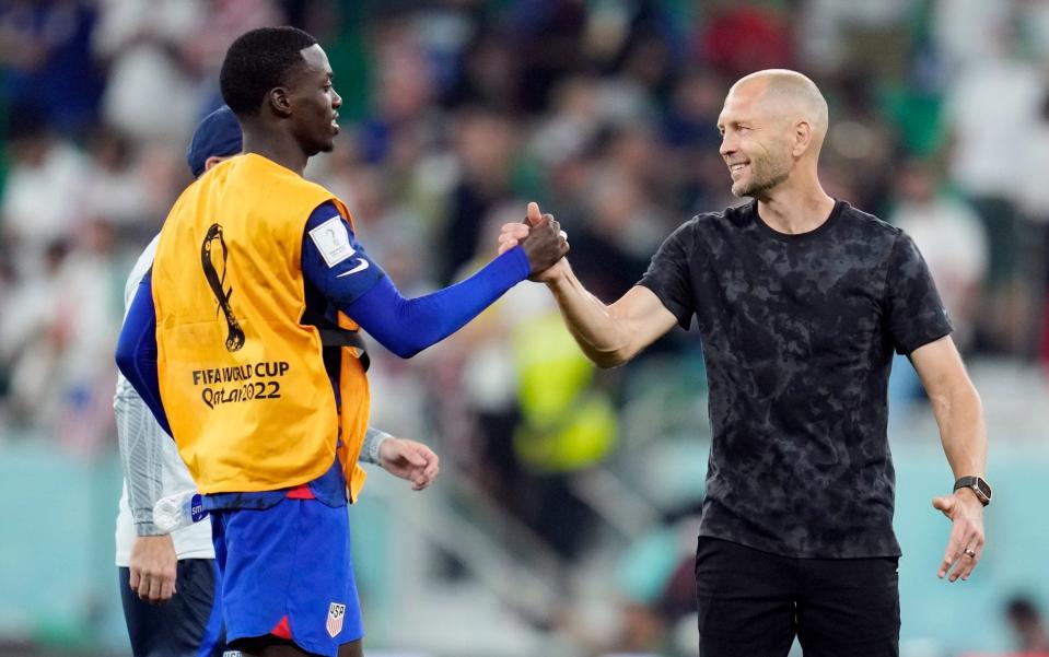 United States' Tim Weah, left, and head coach Gregg Berhalter celebrate after defeating Iran in the World Cup group B soccer match between Iran and the United States - Ashely Landis/AP