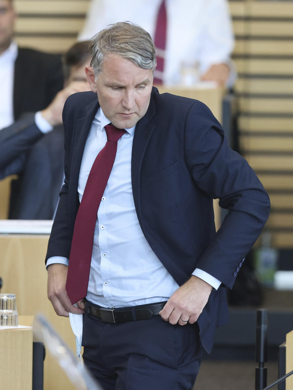 Bjoern Hoecke, parliamentary group leader of the AfD in the Thuringian state parliament, stands on his seat in the plenary hall during the vote in Erfurt, Germany, Friday, July 23, 2021. The far-right Alternative for Germany party failed in an attempt Friday to unseat the left-wing governor of an eastern German state, a long-shot bid that opponents denounced as political theater. (Bodo Schackow/dpa via AP)