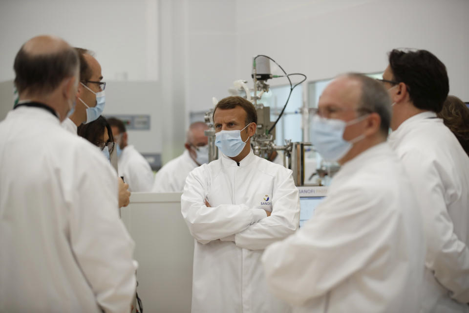 French President Emmanuel Macron, center, visits an industrial development laboratory at the French drugmaker's vaccine unit Sanofi Pasteur plant in Marcy-l'Etoile, near Lyon, central France, Tuesday, June 16, 2020. The visit comes after rival pharmaceutical company AstraZeneca this weekend announced a deal to supply 400 million vaccine doses to EU countries, including France. (Gonzalo Fuentes/Pool via AP)