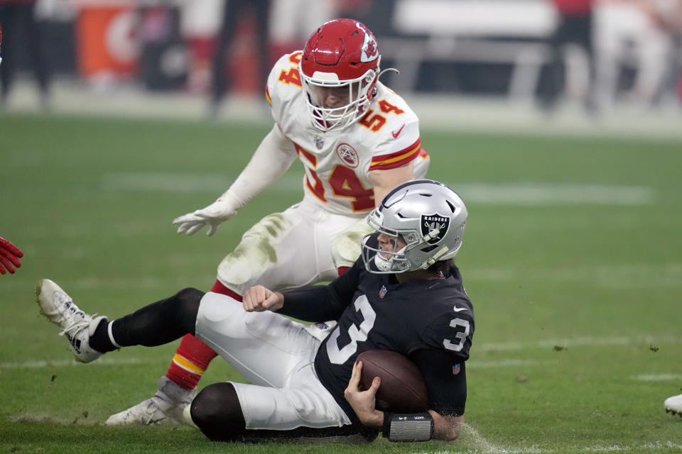 Las Vegas Raiders quarterback Jarrett Stidham (3) slides after running for yardage as Kansas City Chiefs linebacker Leo Chenal (54) defends during the second half of an NFL football game Saturday, Jan. 7, 2023, in Las Vegas. (AP Photo/John Locher)