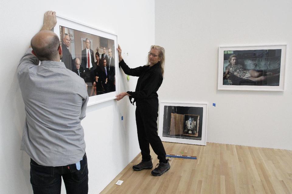 Annie Leibovitz, right, helps Zak Kelley, of Columbus, hang one of her photographic prints before the opening of her exhibition at the Wexner Center for the Arts Friday, Sept. 21, 2012, in Columbus, Ohio. Leibovitz's exhibition features work from her “Master Set,” an authoritative edition of 156 images. (AP Photo/Jay LaPrete)