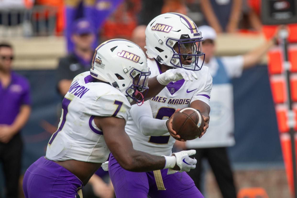 James Madison quarterback Jordan McCloud (2) passes off the ball to running back Ty Son Lawton (7) to run a play during the second half at Scott Stadium.