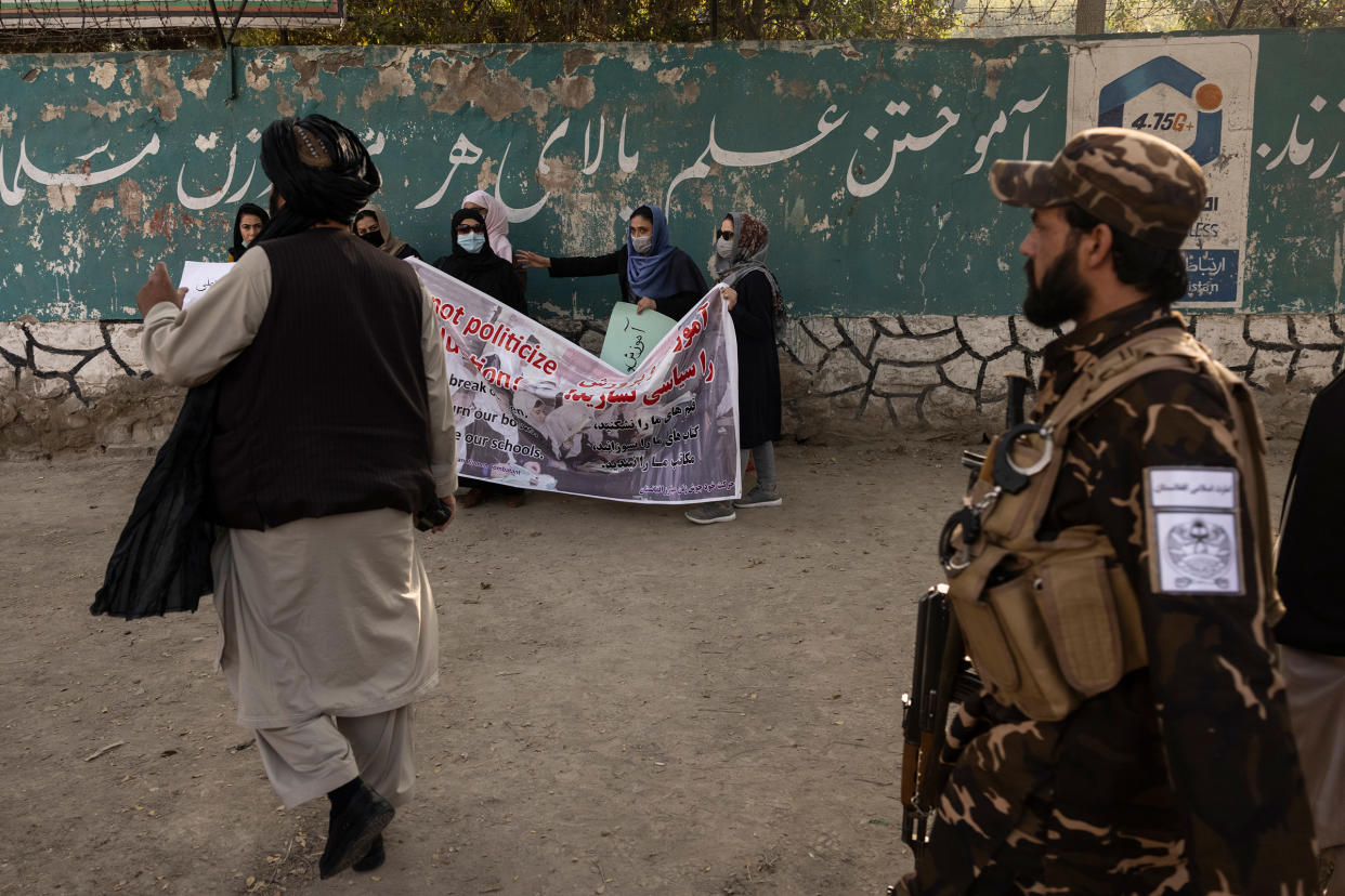 Taliban members disperse a small group of women rallying in support of women's education outside a girls high school in Kabul on Sept. 30.