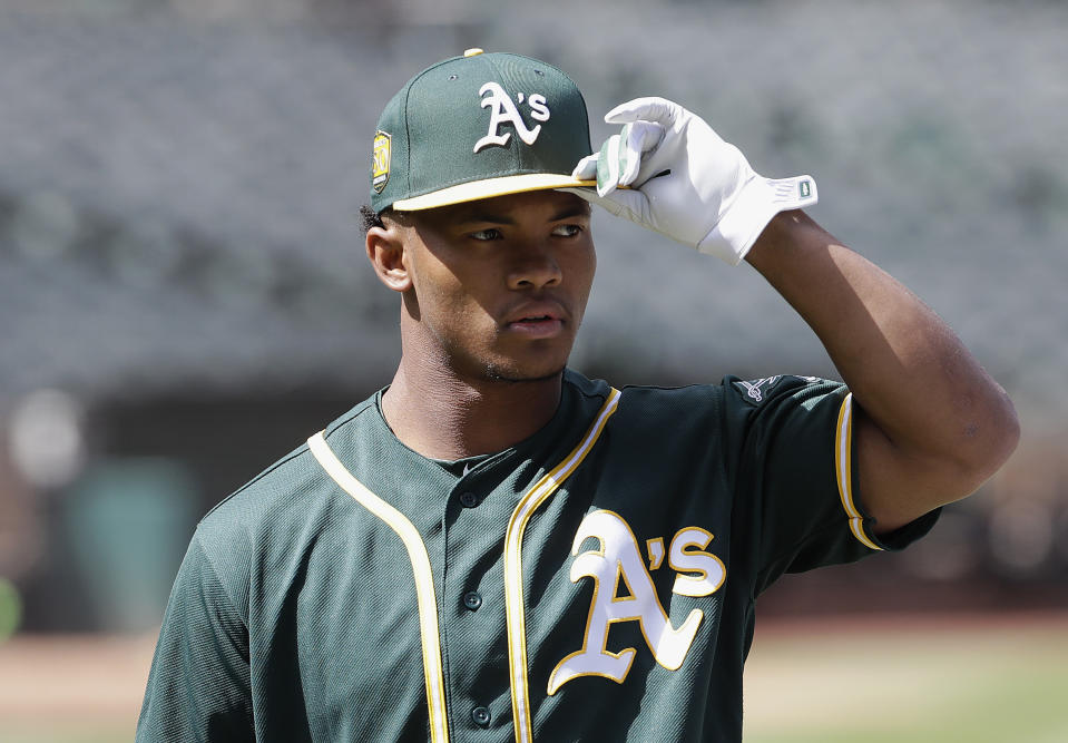 FILE - In this June 15, 2018, file photo, Oakland Athletics draft pick Kyler Murray looks on before a baseball game between the Athletics and the Los Angeles Angels, in Oakland, Calif. Murray's locker remained empty on Monday, Feb. 11, 2019, in the spring training clubhouse of the Oakland Athletics, who say they are uncertain when or if the Heisman Trophy winner will report to the baseball team he signed with last summer. Billy Beane, Oakland’s executive vice president of baseball operation, said talks are continuing with Murray, who may drop baseball to pursue an NFL career. (AP Photo/Jeff Chiu, File)