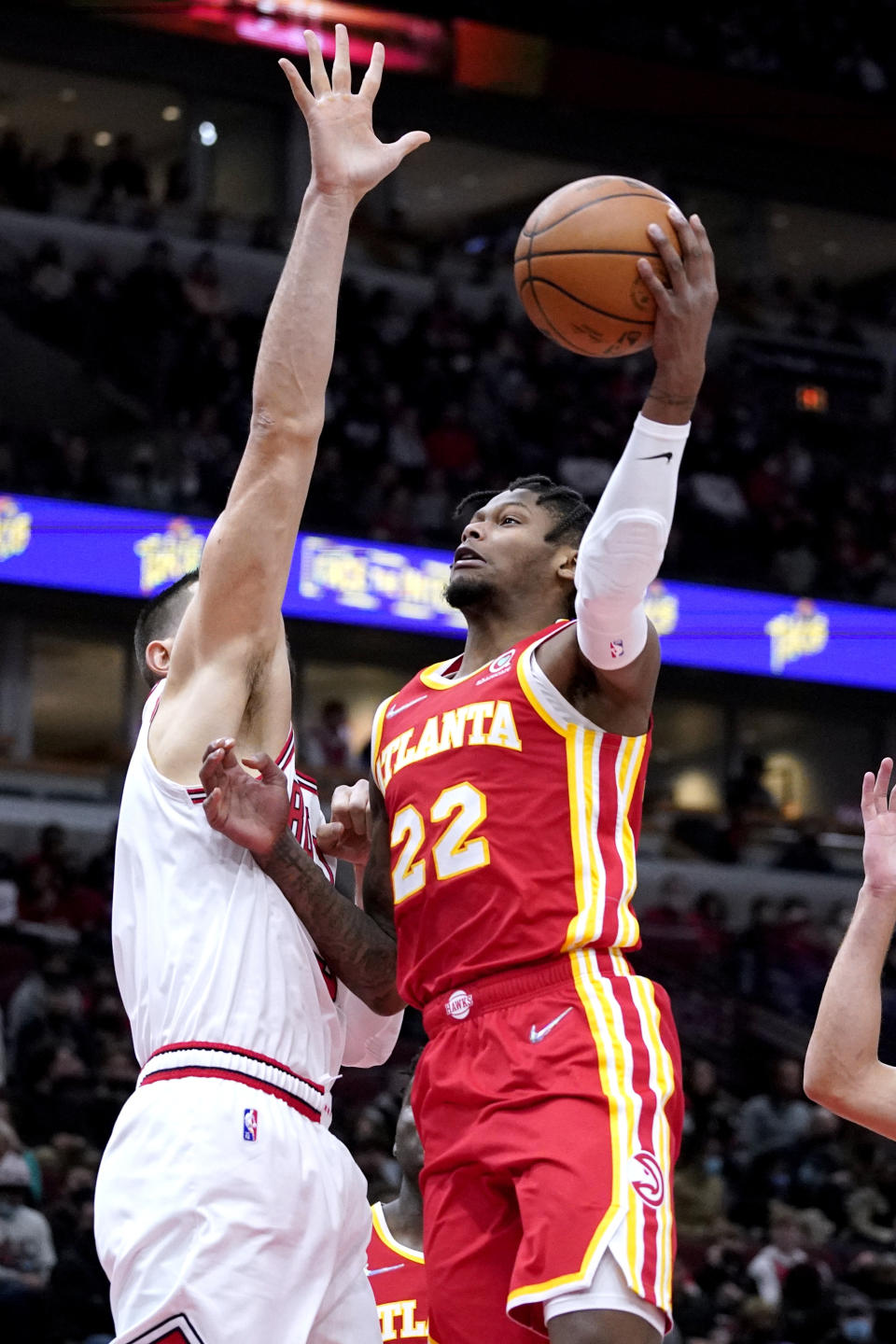 Atlanta Hawks forward Cam Reddish, right, shoots against Chicago Bulls center Nikola Vucevic during the first half of an NBA basketball game in Chicago, Wednesday, Dec. 29, 2021. (AP Photo/Nam Y. Huh)