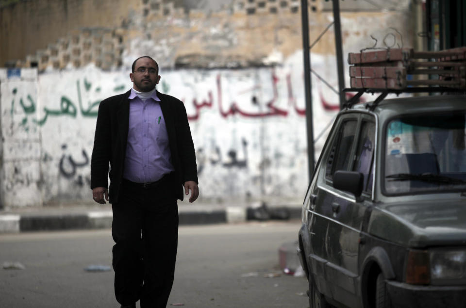 In this Tuesday, March 11, 2014 photo, Ahmed Zeitouniya, 32, an employee of the Culture Ministry, walks on his way back from work to his home in Gaza City in the northern Gaza Strip. Gaza's Hamas rulers have been hit by the worst economic crisis since seizing the territory seven years ago and face growing discontent, even among core supporters, because there's no sign of relief from a blockade enforced not only by Israel but also by a suddenly hostile Egypt. (AP Photo/Hatem Moussa)