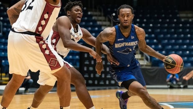 Nighthawks' Cat Barber, right, dribbles past two members of the Blackjacks during his team's 90-87 victory over Ottawa on Monday. Barber scored a game-high 24 points and clocked 33 minutes to help Guelph register its first win of the season.  (@Gnighthawks/Twitter - image credit)