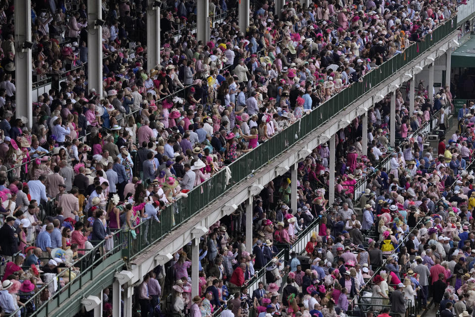 Fans watch the start of the 148th running of the Kentucky Oaks horse race at Churchill Downs on Friday, May 6, 2022, in Louisville, Ky. (AP Photo/Charlie Riedel)