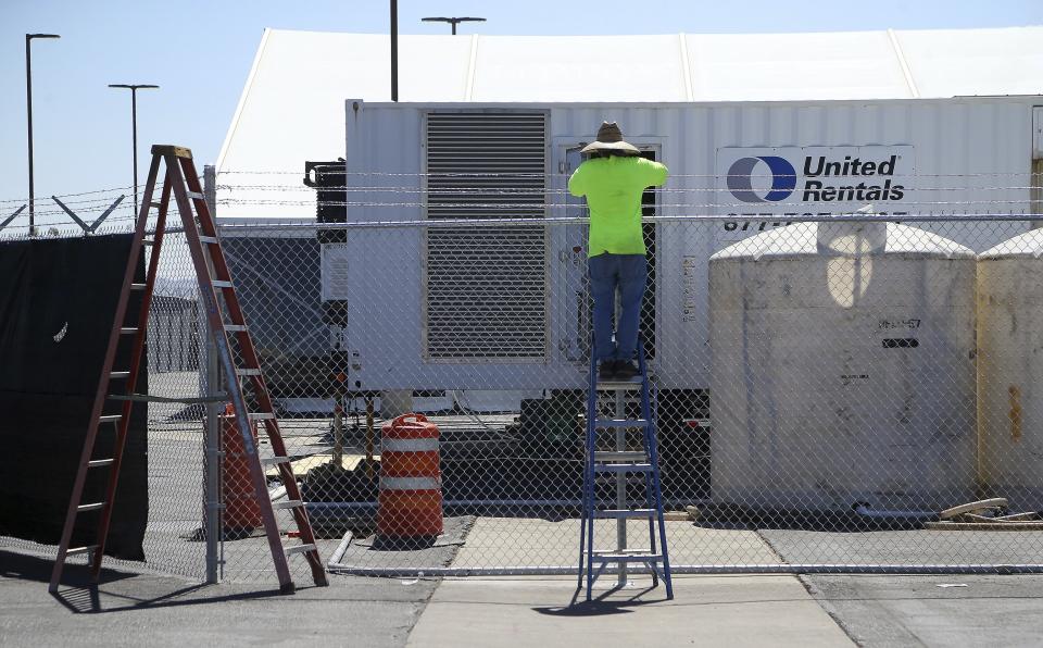 Workers put the finishing touches on the new U.S. Border Patrol 500-person tent facility during a media tour unveiling, that is meant to process detained immigrant children and families who cross the U.S. border Friday, June 28, 2019, in Yuma, Ariz. The Border Patrol says it will start placing families there on Friday night. (AP Photo/Ross D. Franklin)