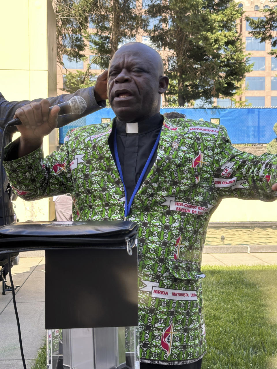 The Rev. Jerry Kulah, of Liberia, leads a prayer outside the Charlotte Convention Center, in Charlotte, N.C., Thursday, May 2, 2024, at a gathering of African delegates where he decried a vote by the General Conference of the United Methodist Church that replaced its definition of marriage with one that doesn't limit marriage to a heterosexual couple. He said the denomination is contradicting the Bible's teaching. (AP Photo/Peter Smith)