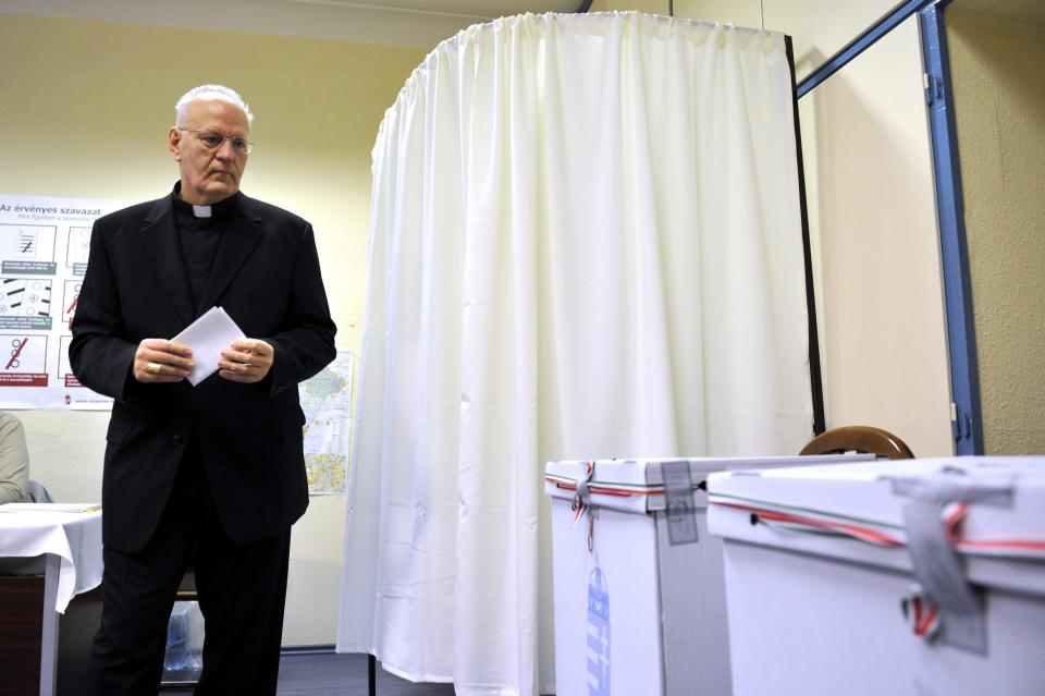 Primate of the Hungarian Catholic Church, Archbishop of Esztergom-Budapest, Cardinal Peter Erdo casts his vote at a polling station in Budapest during the parliamentary elections in Hungary, Sunday, April 6, 2014. Hungary's governing party is tipped to win parliamentary elections Sunday, while a far-right party is expected to make further gains, according to polls. Prime Minister Viktor Orban's Fidesz party and its small ally, the Christian Democrats, are expected to win easily and they may even retain the two-thirds majority in the legislature gained in 2010 which allowed them to pass a new constitution, adopt unconventional economic policies, centralize power and grow the state's influence at the expense of the private sector. (AP Photo/MTI,Attila Kovacs)