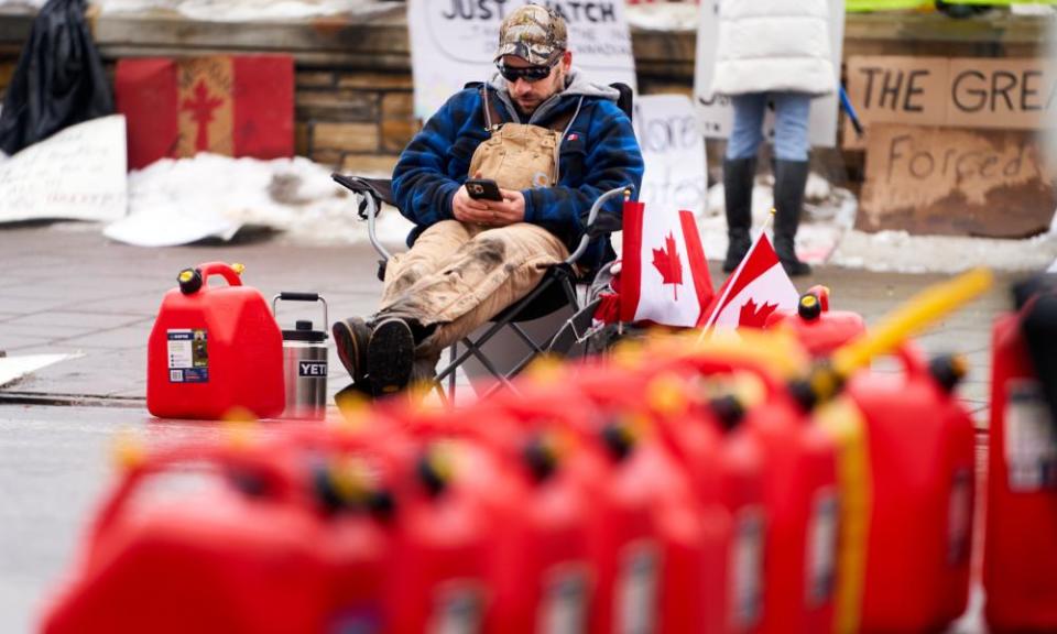 A supporter takes a break as he uses cellphone in downtown Ottawa on Thursday.