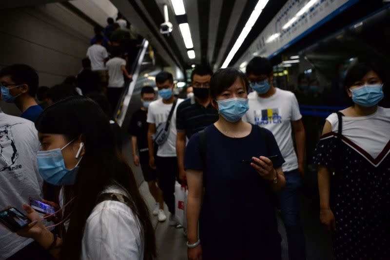 People wearing face masks walk inside a subway station during morning rush hour, following an outbreak of the novel coronavirus disease (COVID-19), in Beijing