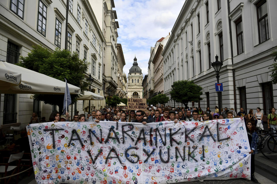 Students hold a banner reading "we stand by our teacher" during a protest in solidarity with their teachers in front of the St. Stephen's Basilica in Budapest, Hungary, Friday, Sept. 2, 2022. Public schools in Poland and Hungary are facing a shortage of teachers at a time when both countries are taking in many Ukrainian refugee children. For years, teachers have been fleeing public schools over grievances regarding low wages and a sense of not being valued by their governments. (AP Photo/Anna Szilagyi)