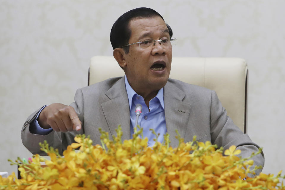 FILE - In this Jan. 30, 2020, file photo, Cambodia's Prime Minister Hun Sen gestures during a speech on the current state of a new virus from China in Phnom Penh. A Cambodian court began Thursday, Nov. 26, hearing the cases of nearly 130 opponents and government critics charged with treason for taking part in nonviolent political activities over the past three years. (AP Photo/Heng Sinith, File)